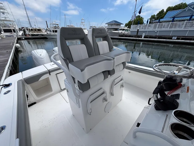 Slide: The Image of 2025 Regulator 23 boat interior with dual seats at marina dock. - 16