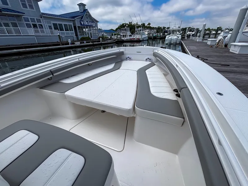 Slide: The Image of 2025 Regulator 23 boat interior with cushioned seating at a marina dock. - 17