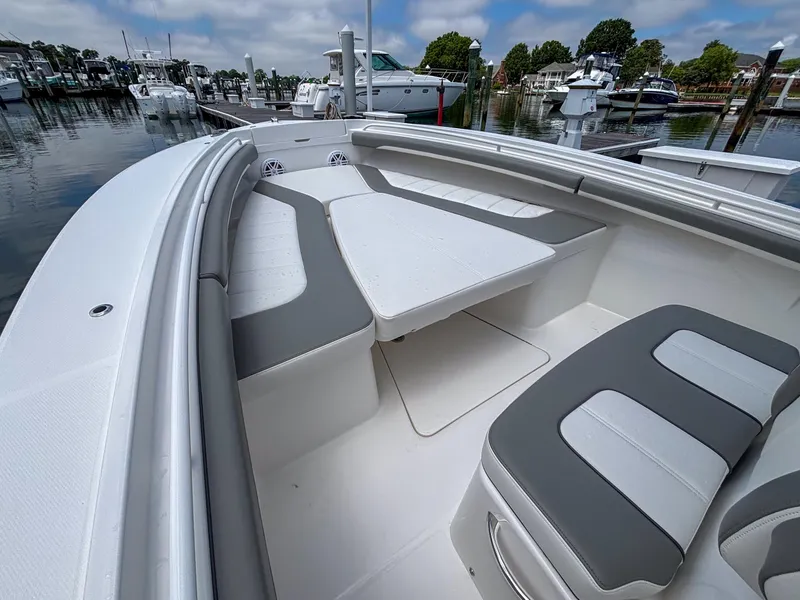 Slide: The Image of 2025 Regulator 23 boat with spacious seating and table in a marina setting. - 18