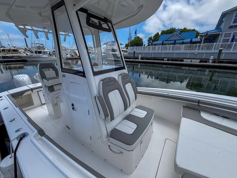 Slide: The Image of 2025 Regulator 23 boat interior with seating, docked at a marina under a partly cloudy sky. - 21