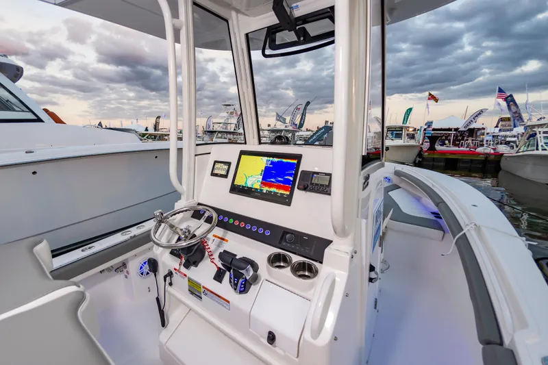 Slide: The Image of 2025 Regulator 23 boat cockpit with advanced navigation system at marina. - 25