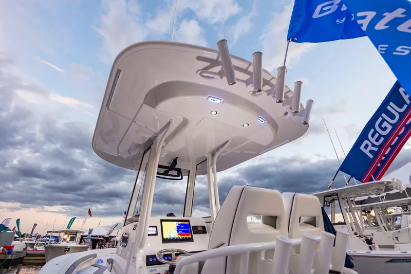 Slide: The Image of 2025 Regulator 23 boat with modern helm, flags, and cloudy sky backdrop. - 28