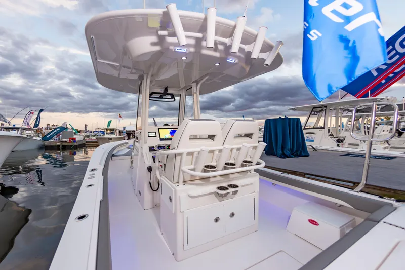Slide: The Image of 2025 Regulator 23 boat interior at marina, showcasing helm and seating under cloudy sky. - 29