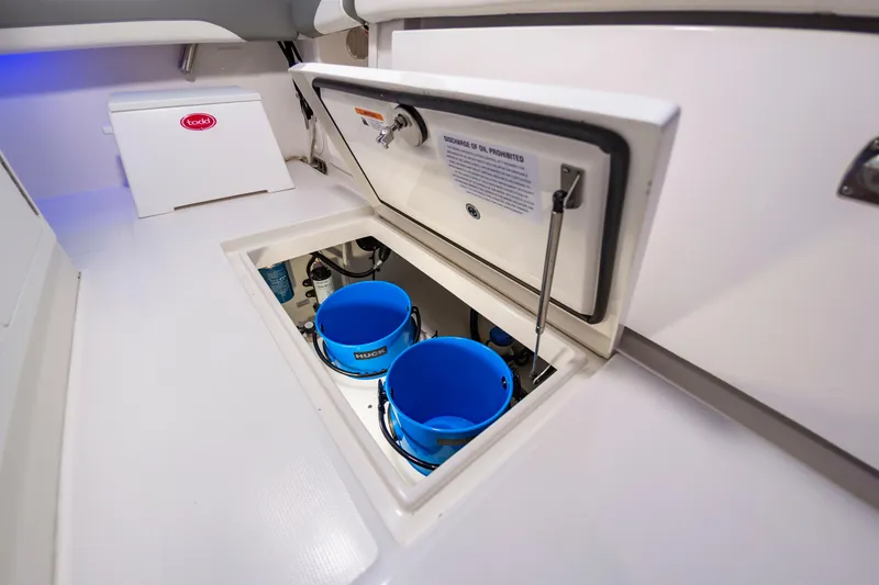 Slide: The Image of 2025 Regulator 23 boat storage compartment with blue buckets and white interior. - 32