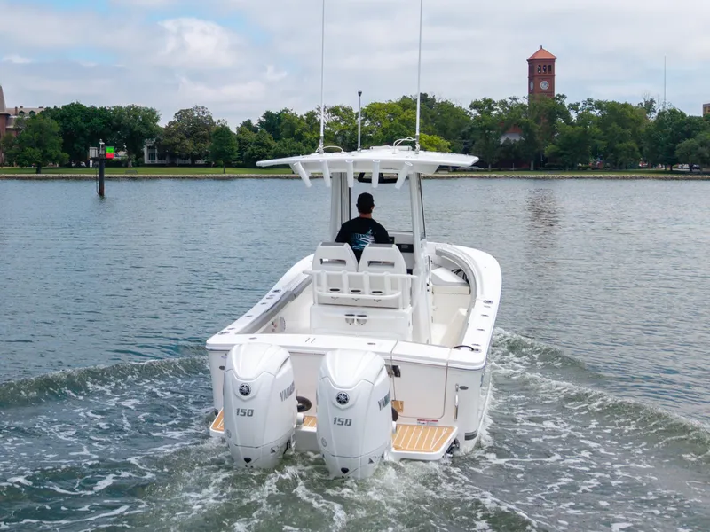 Slide: The Image of 2025 Regulator 23 boat with dual Yamaha engines cruising on a calm river. - 6