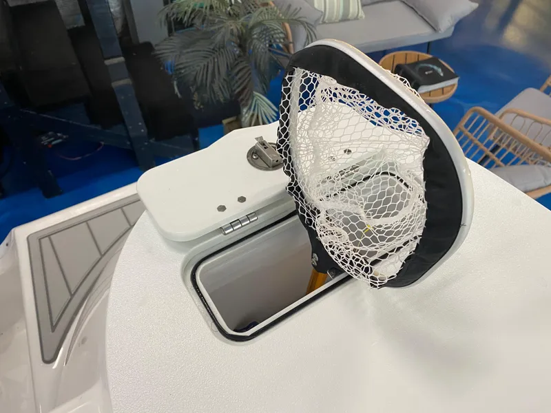 Slide: The Image of Sea Fox 228 Commander 2025 boat with open storage compartment and fishing net. - 21