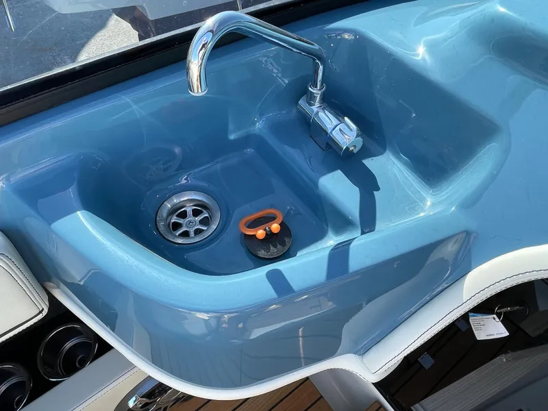 Slide: The Image of 2022 Cranchi 26 Classic boat sink with faucet and blue basin. - 21