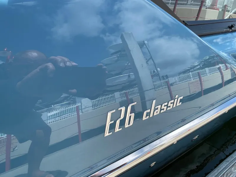 Slide: The Image of 2022 Cranchi 26 Classic boat with reflective surface and logo. - 28