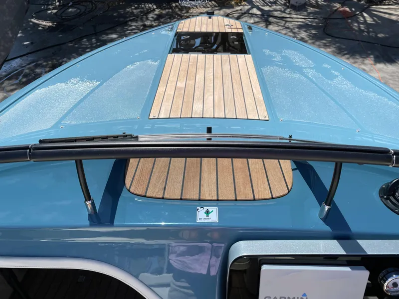 Slide: The Image of 2022 Cranchi 26 Classic boat with blue hull and wooden deck. - 9