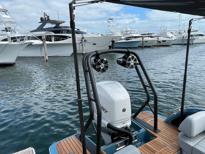 Slide: The Image of 2022 Cranchi 26 Rider boat with outboard motor and speakers docked at marina. - 32
