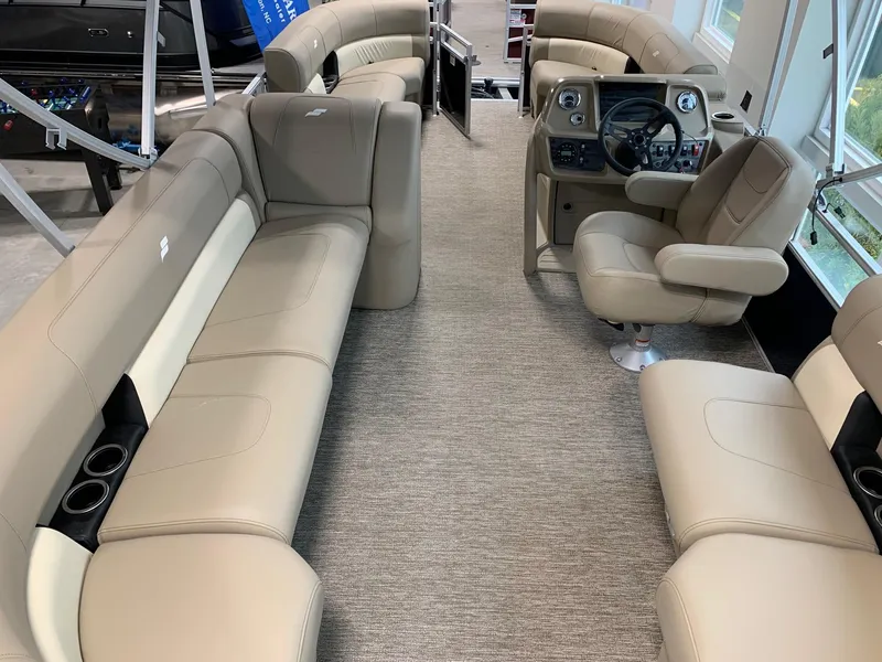 Slide: The Image of 2024 Starcraft LX20 R pontoon boat interior with beige seating and captain's chair. - 2