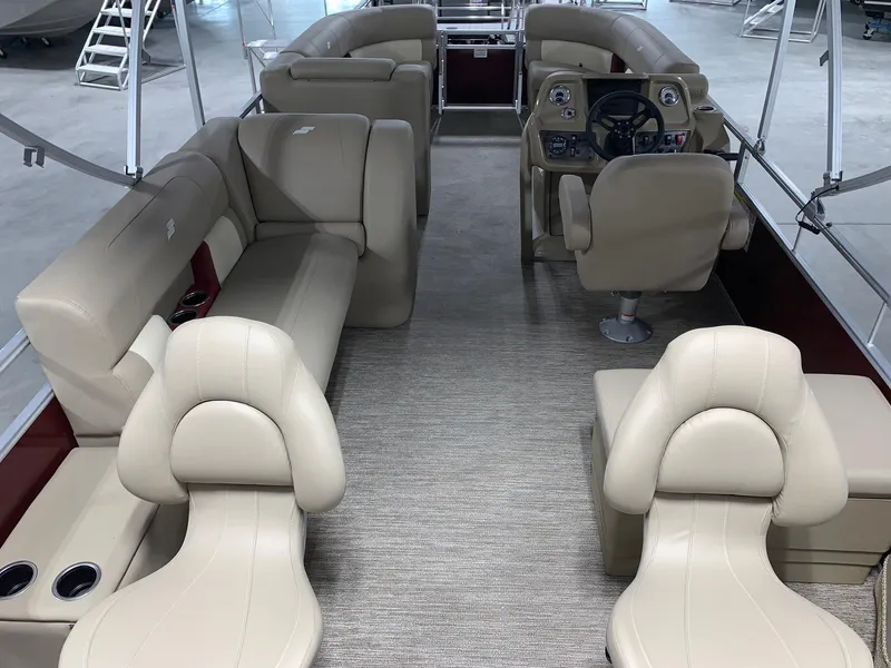 Slide: The Image of 2024 Starcraft LX22 F pontoon boat interior with beige seating and steering console. - 3