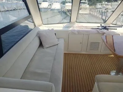 Slide: The Image of Interior of 2003 Riviera 48 Conv yacht with plush seating and wooden flooring. - 12