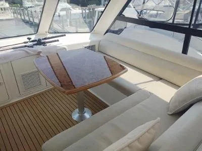 Slide: The Image of Luxurious interior of 2003 Riviera 48 conv yacht with elegant seating and wooden table. - 13
