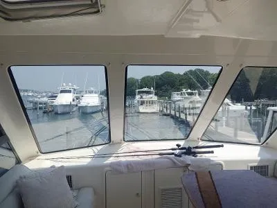 Slide: The Image of Interior view from a 2003 Riviera 48 Conv yacht, overlooking a marina with docked boats. - 14