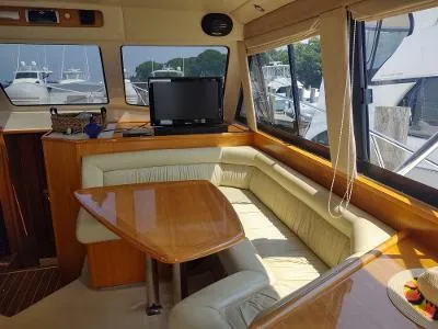 Slide: The Image of Interior of 2003 Riviera 48 Conv yacht with dining area and windows. - 18