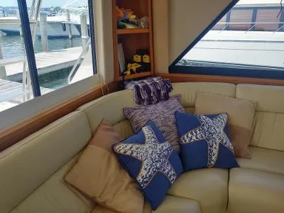 Slide: The Image of Interior of 2003 Riviera 48 conv yacht with starfish-themed cushions and marina view. - 19