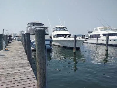 Slide: The Image of Boats docked at a marina, featuring a 2003 Riviera 48 conv yacht. - 2