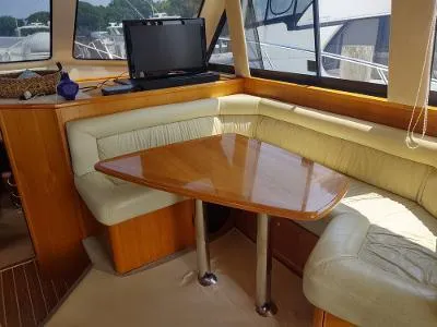 Slide: The Image of Interior of 2003 Riviera 48 Conv yacht with cozy dining area and wooden table. - 21