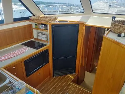 Slide: The Image of Interior of 2003 Riviera 48 Conv yacht with wooden cabinetry and modern appliances. - 23