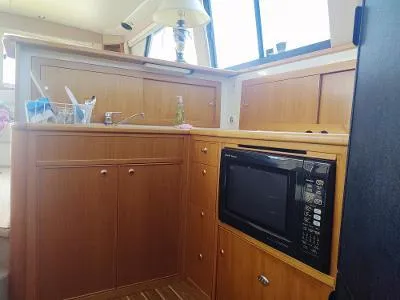 Slide: The Image of 2003 Riviera 48 Conv yacht kitchen with wooden cabinets and built-in microwave. - 24