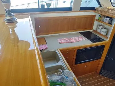 Slide: The Image of Galley kitchen in 2003 Riviera 48 conv yacht with wooden cabinetry and modern appliances. - 25