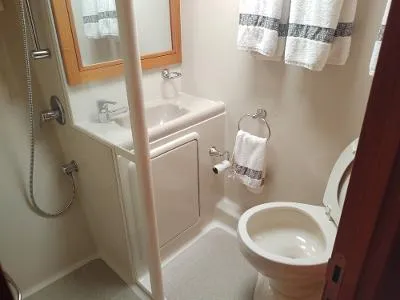 Slide: The Image of Compact bathroom in 2003 Riviera 48 conv yacht with sink, toilet, and shower. - 27