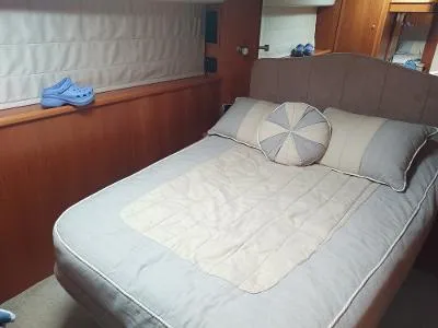 Slide: The Image of Cozy bedroom in 2003 Riviera 48 Conv yacht with plush bedding and wooden accents. - 29
