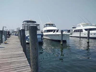 Slide: The Image of Docked 2003 Riviera 48 Convertible yacht at marina with other boats. - 3