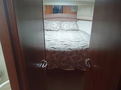 Slide: The Image of Cozy bedroom interior of 2003 Riviera 48 Conv yacht with patterned bedding. - 30