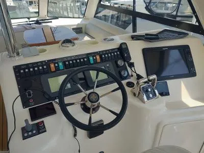 Slide: The Image of Control panel of a 2003 Riviera 48 conv yacht with steering wheel and navigation equipment. - 39
