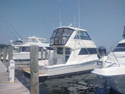 Slide: The Image of 2003 Riviera 48 Convertible yacht docked at marina under clear sky. - 5