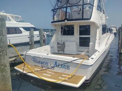 Slide: The Image of 2003 Riviera 48 Conv yacht docked, named "Buenos Aires," in a marina setting. - 6