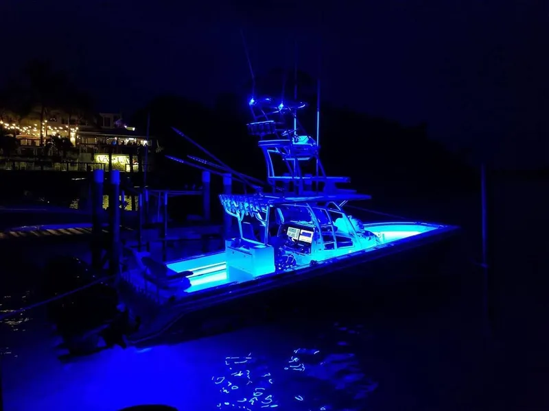 Slide: The Image of 2023 Nor-Tech 392 Super Fish boat illuminated with blue lights at night. - 4