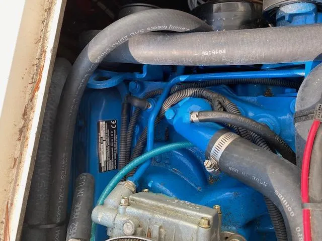 Slide: The Image of 1972 Bertram Express engine compartment with blue components and hoses. - 13