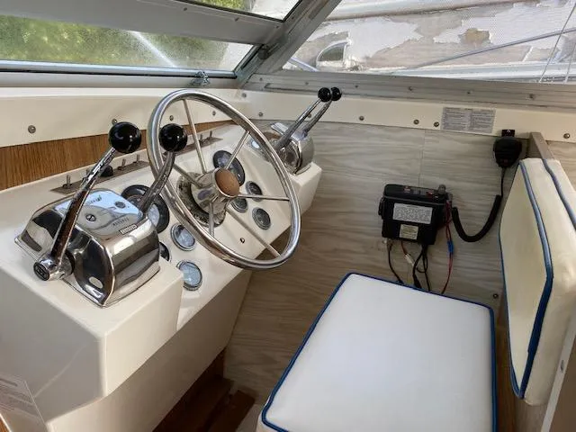 Slide: The Image of 1972 Bertram Express boat helm with steering wheel, controls, and cushioned seat. - 7