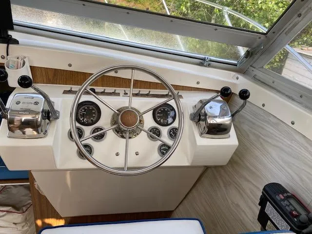 Slide: The Image of 1972 Bertram Express boat helm with steering wheel and control levers. - 8