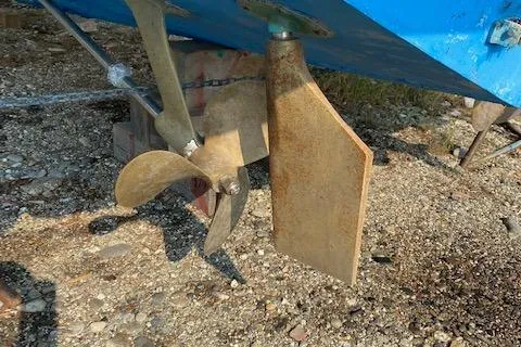 Slide: The Image of 1972 Bertram Express boat propeller and rudder on gravel surface. - 18