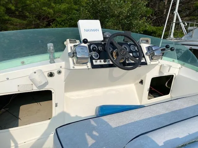 Slide: The Image of 1972 Bertram Express boat dashboard with steering wheel and Navman system. - 2