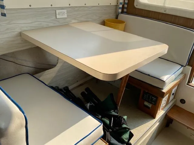 Slide: The Image of 1972 Bertram Express boat interior with dining area and cushioned seating. - 5