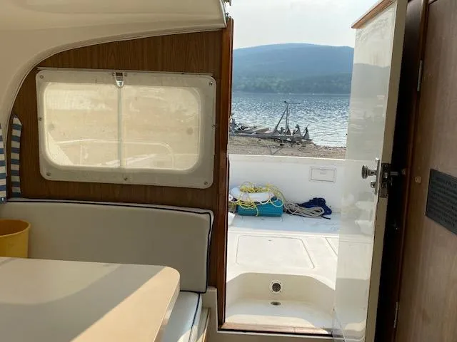 Slide: The Image of Interior view of a 1972 Bertram Express boat with open door to scenic waterfront. - 6