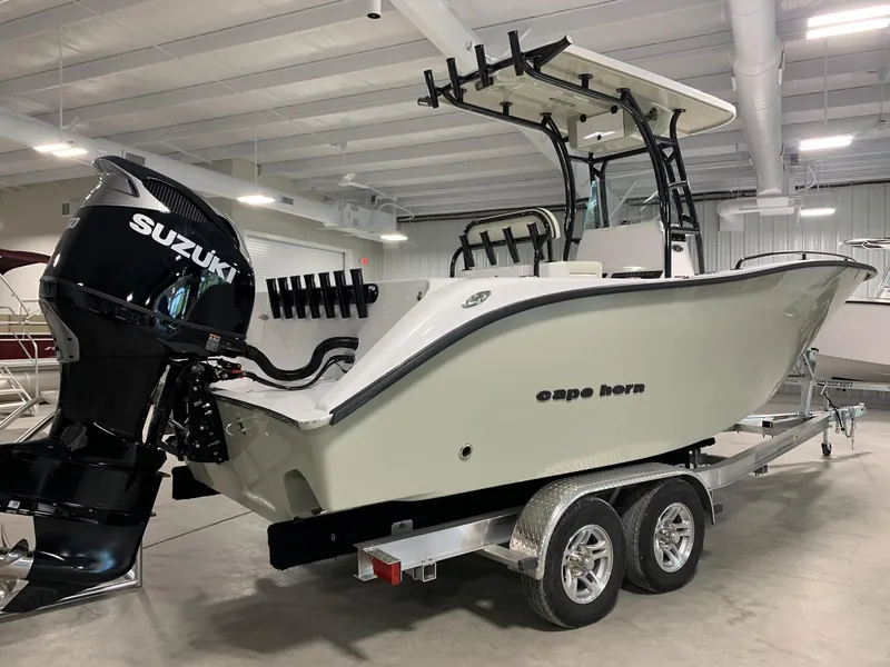 Slide: The Image of 2024 Cape Horn 22 OS boat with Suzuki outboard motor on trailer in indoor showroom. - 2