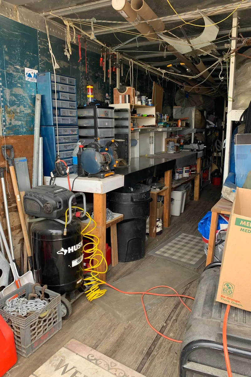 Slide: The Image of Cluttered workshop with tools, storage bins, and a Husky air compressor. - 20