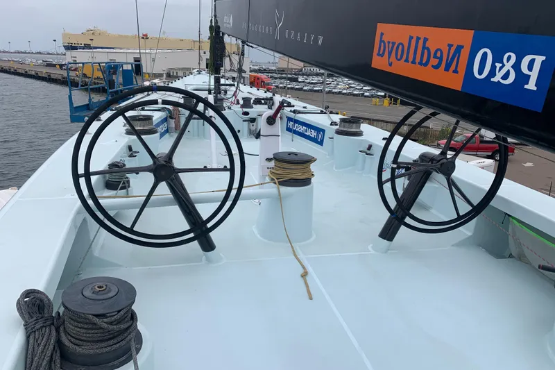 Slide: The Image of Custom 2000 Americas Cup Class 75 yacht deck with dual steering wheels and rigging. - 21