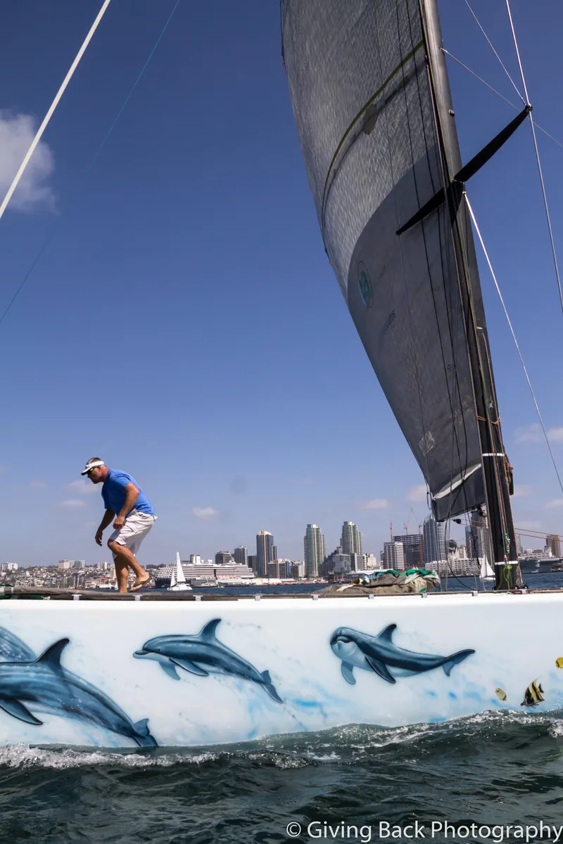Slide: The Image of Sailing yacht with dolphin artwork, America's Cup Class 75, 2000, city skyline in background. - 7