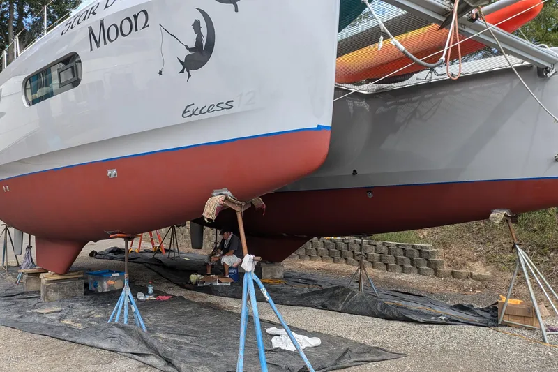 Slide: The Image of 2020 Excess 12 catamaran on land, undergoing maintenance with visible supports and tools. - 21