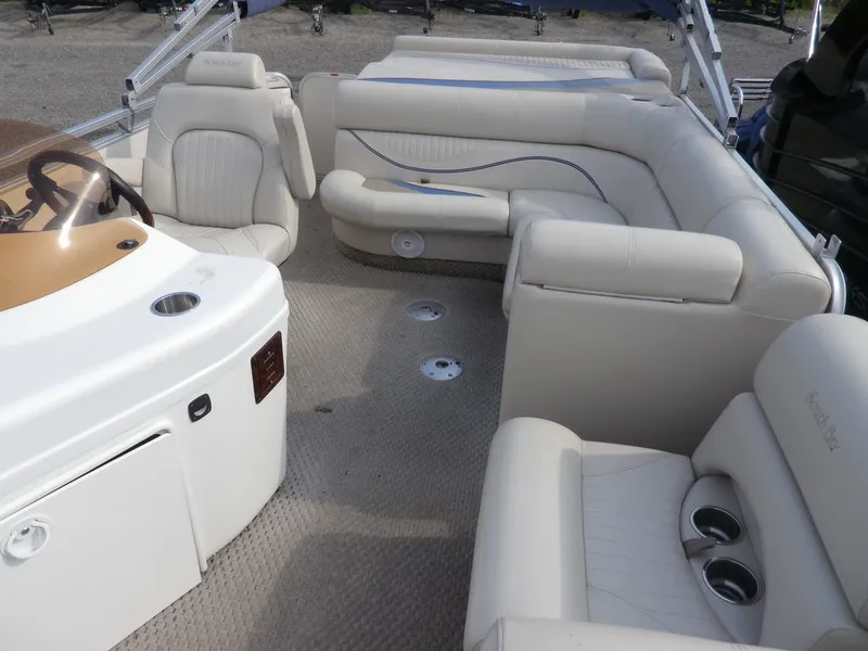 Slide: The Image of Interior of a 2006 South Bay 925 pontoon boat with beige seating. - 6