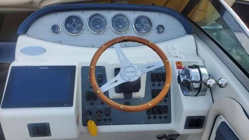 Slide: The Image of 2006 Chris-Craft 36 Corsair Heritage boat dashboard with wooden steering wheel and gauges. - 35