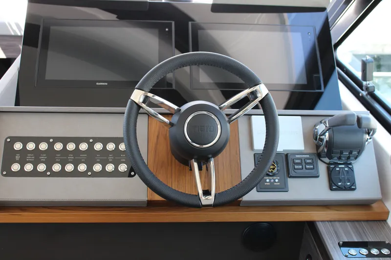 Slide: The Image of 2020 Tiara Yachts C49 Coupe helm with steering wheel and control panel. - 19