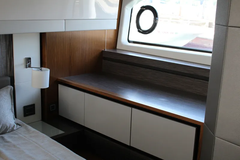 Slide: The Image of Interior of 2020 Tiara Yachts C49 Coupe, featuring modern wood cabinetry and a porthole window. - 47